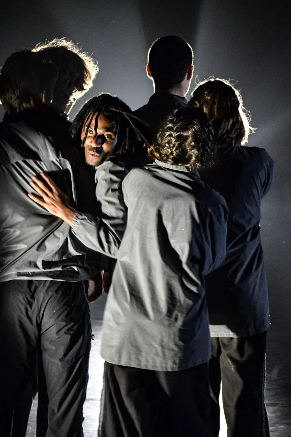 A group pressed around a single performer who looks out past them