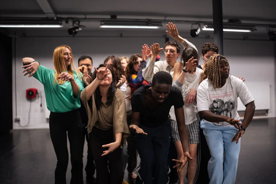 A laughing cluster of participants with their arms raised