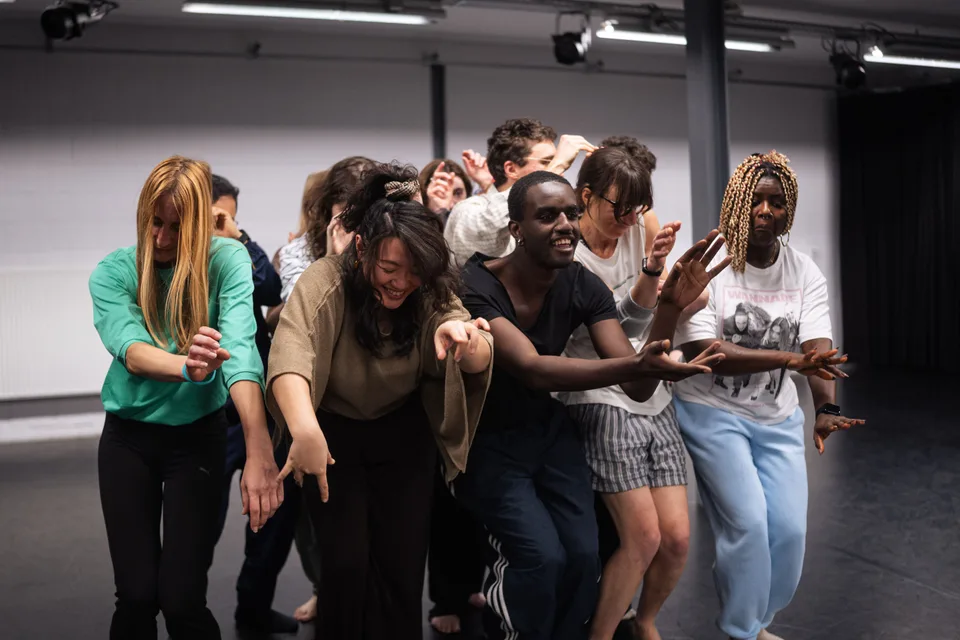 A tight group of participants pressed together, leaning as one body