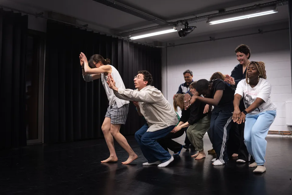 A participant crouched low and reaching forward, the group massed behind